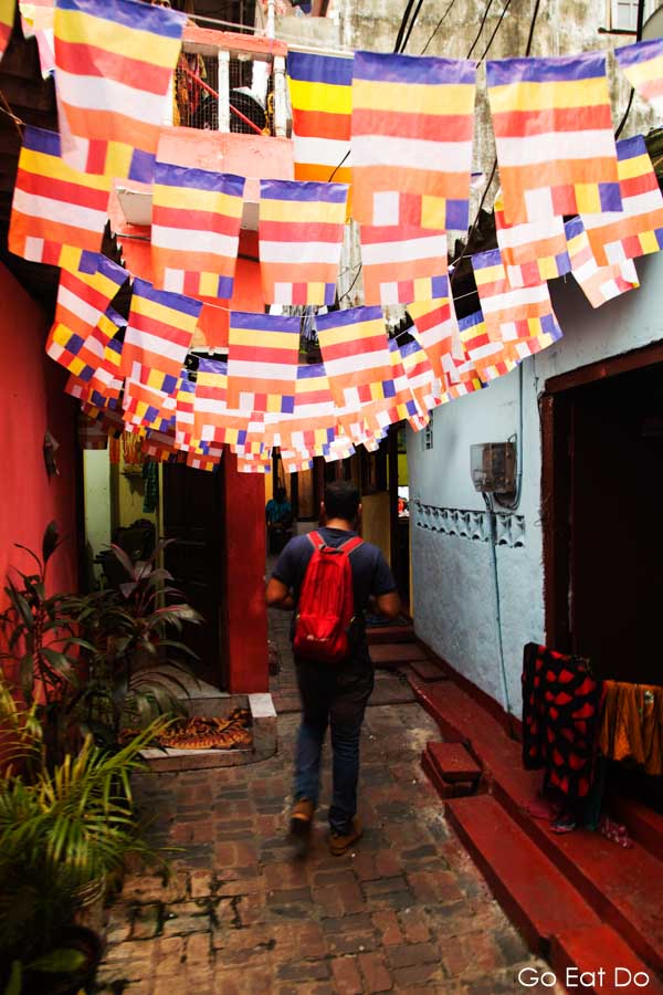 Arshad Yassim leading a walking tour below colourful flags in Colombo, Sri Lanka