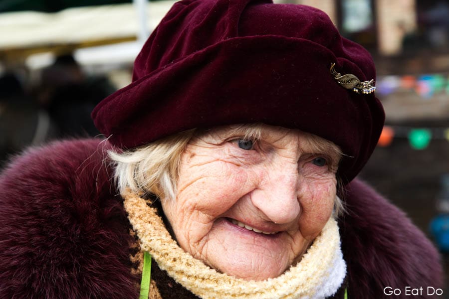 Smiling woman in a hat selling cakes at a Christmas market in Riga, Latvia