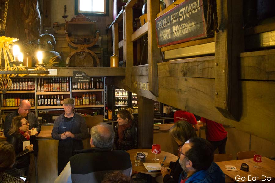 People sampling Dutch whisky, jenever and asparagus liqueur by the bar of the Ijsvogel distillery next to the castle gardens at Arcen in the Netherlands.