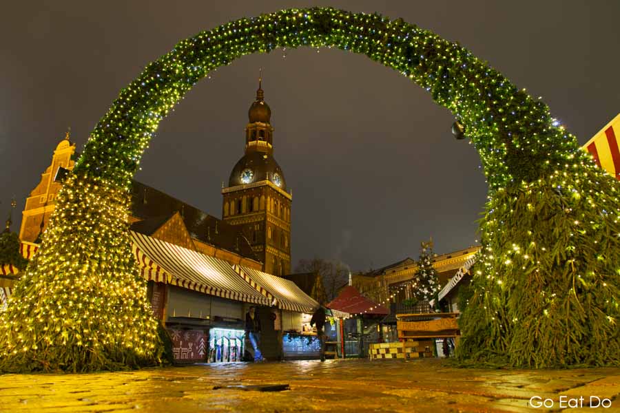 Evangelical Lutheran Cathedral of Riga seen through an illuminated arch at the Christmas Market, in central Riga, Latvia