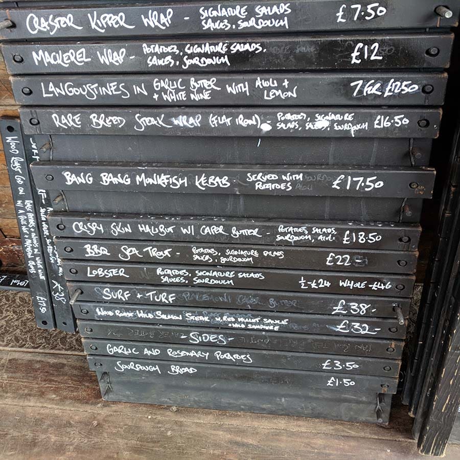 Riley's Fish Shack menu, written on a chalkboard, listing freshly landed fish and seafood served at the seafront restaurant in Tynemouth