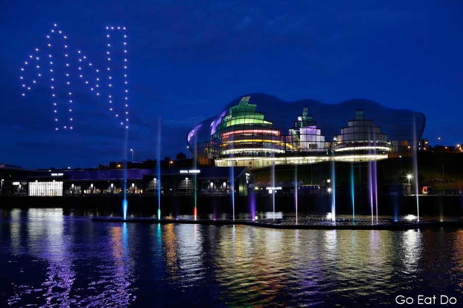Drones display forming Great Exhibition of the North logo in night sky above the Sage Gateshead in NewcastleGateshead