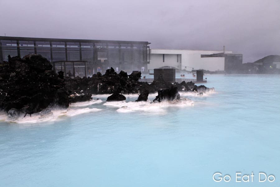Volcanic rocks jut from the geothermally heated pool of the Blue Lagoon in Iceland