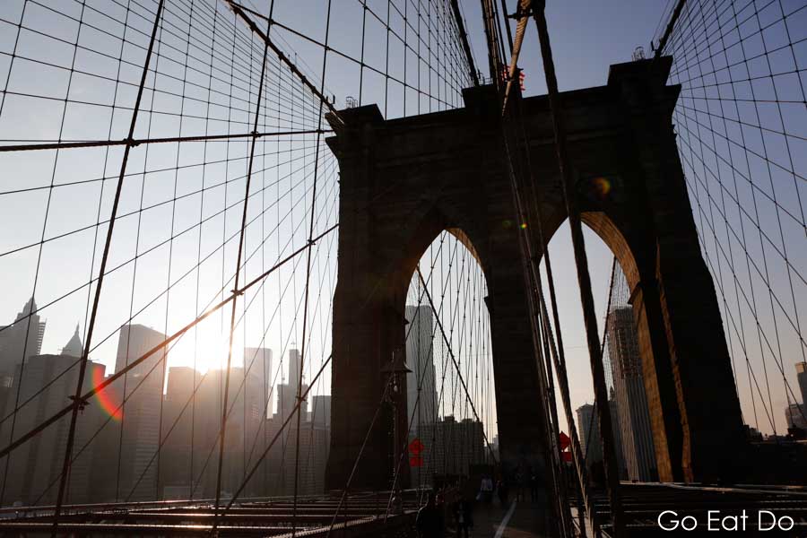 Sunlight behind the skyscrapers of Manhattan seen from the Brooklyn Bridge in New York City, USA