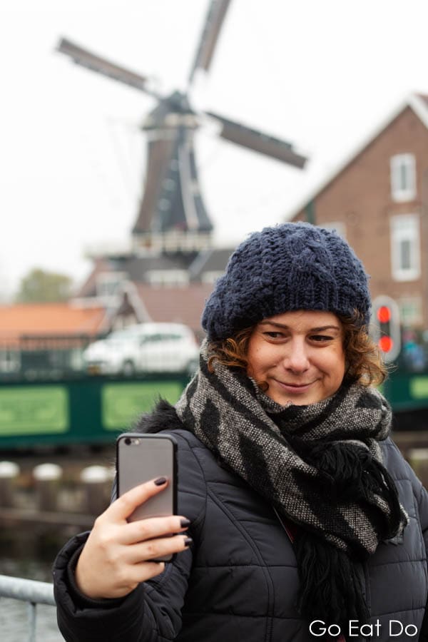 A woman takes a selfie in front of the De Adriaan Windmill in Haarlem.