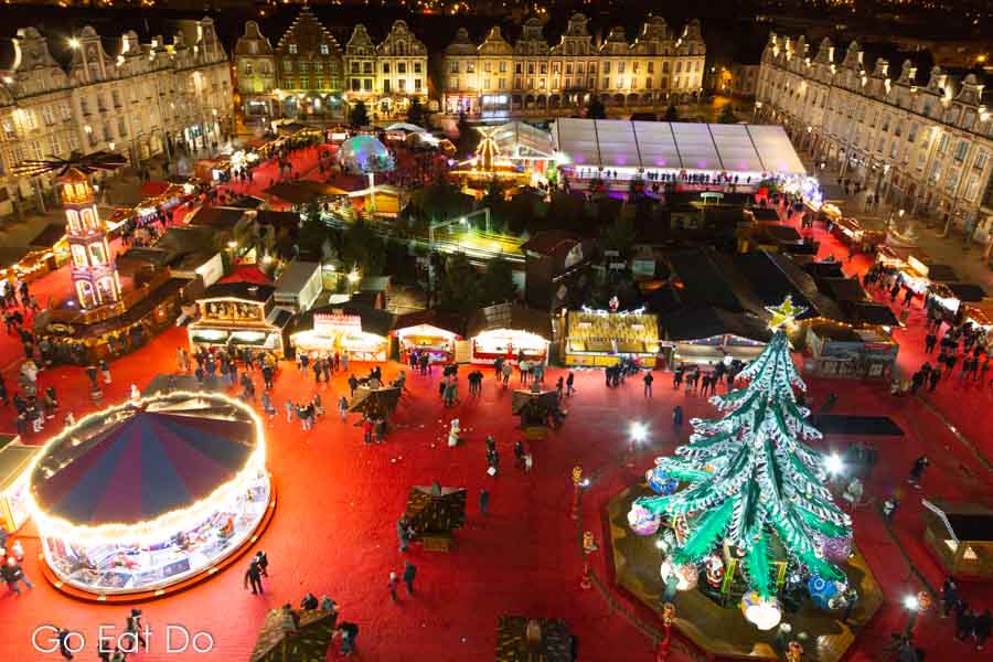 Wooden stalls and a tree on the red carpet of Arras Christmas Market on the Grand Place on Arras, France