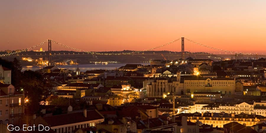 Golden dusk over April 25 Suspension Bridge, Tagus River and city of Lisbon