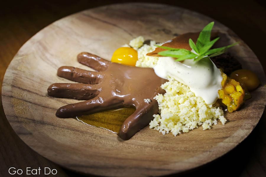 Dessert with a chocolate hand and mango in Belgium