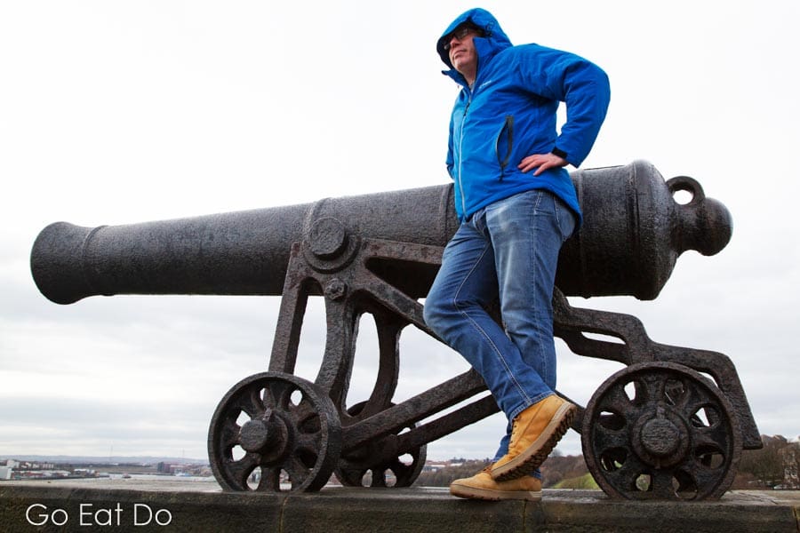 Blogger Stuart Forster wearing the Snugpak Torrent Jacket with the hood up by a cannon