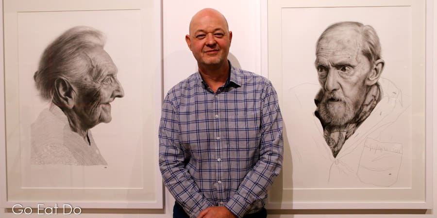 Artist Andrew Tift by portraits that are part of his 'One Day You’ll Be Older Too' series, exhibited at Sunderland Museum.
