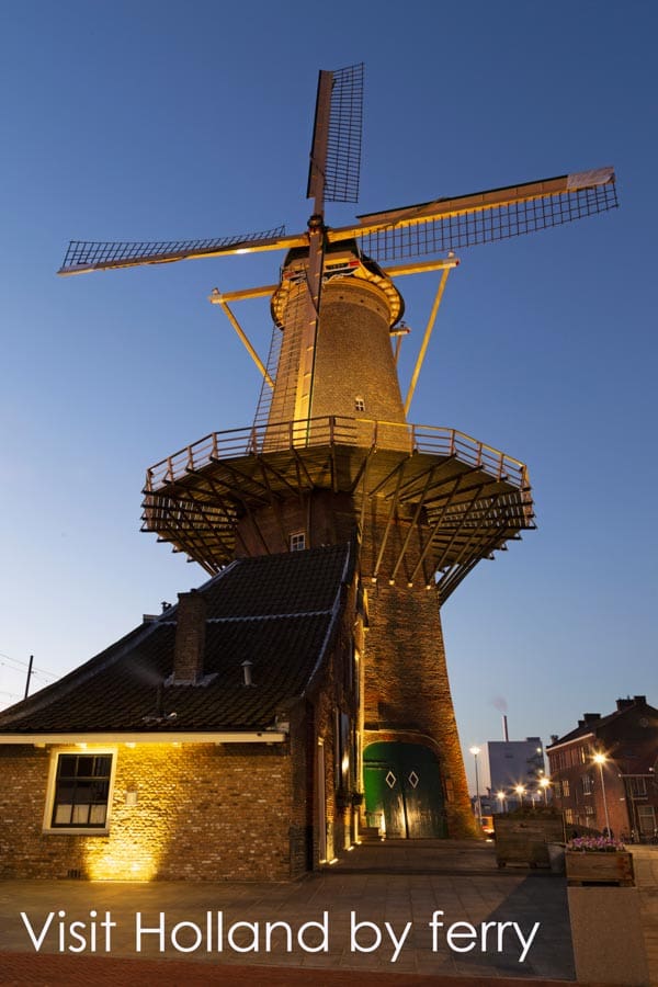 Pinterest pin for the Go Eat Do blog post about visiting Holland by ferry. It shows Molen de Roos windmill in Delft at dusk