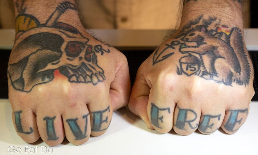 Tattoos reading LIVE FREE on the hands of served Davey Jones at Miller's All Day in Charleston, South Carolina, USA