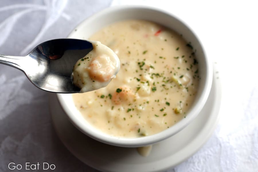 Dipping a spoon into bowl of chowder served at Cupids in Newfoundland and Labrador, Canada