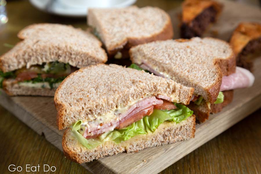 Ham sandwiches served in brown, wholemeal bread, served during an English afternoon tea.
