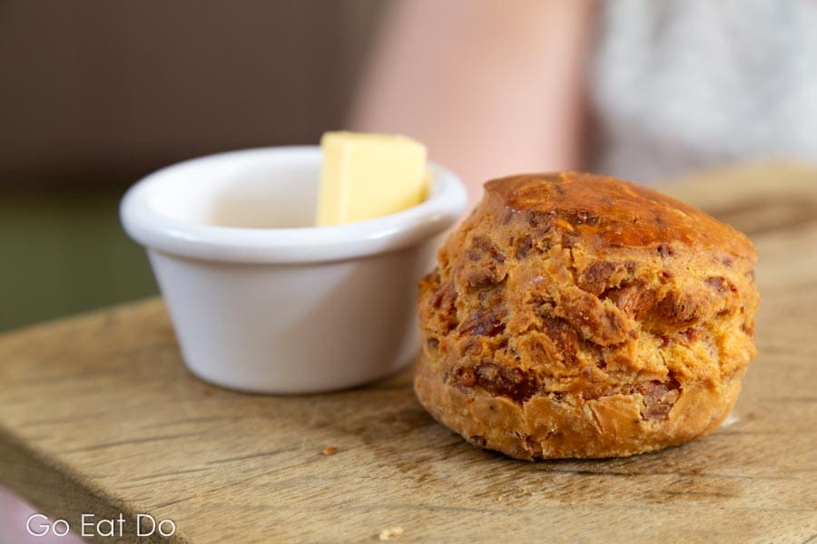 Cheese scone served with butter during rustic afternoon tea at Teapot with a wool tea cosy plus salt and pepper pots at St Mary's Inn, Northumberland