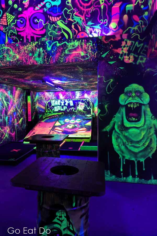 Luminous street art glows by a pinball style hole at Ghetto Golf crazy golf course in Newcastle
