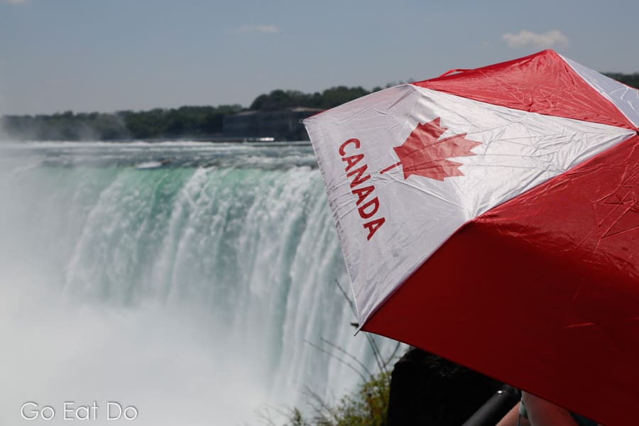 Person with a Canada umbrella viewing the Horseshoe Falls from Niagara Parkway in Niagara Falls, Ontario, Canada