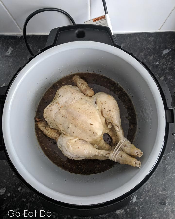 Raw organic chicken in the pot of the Ninja Foodi Multi-cooker