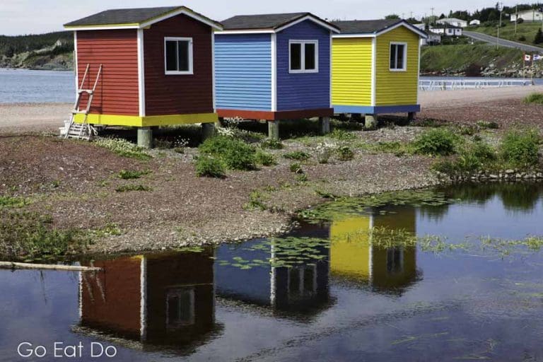 Colourfully painted huts by the shore of the Atlantic Ocean reflect in