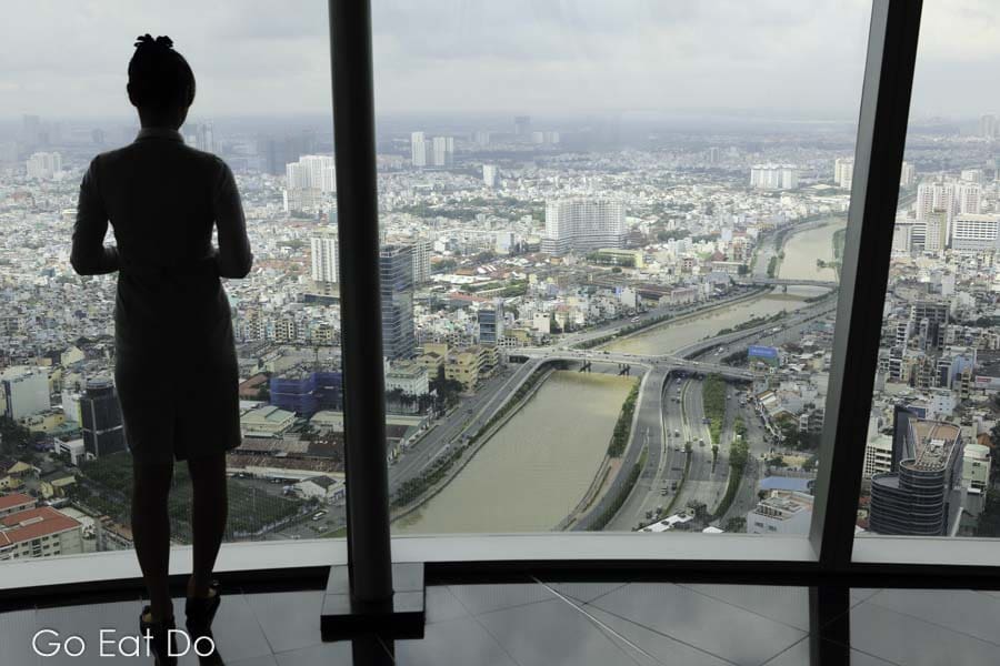 A woman views Ho Chi Minh City and the Saigon river from the Saigon Skydeck in the Bitexco Financial Tower