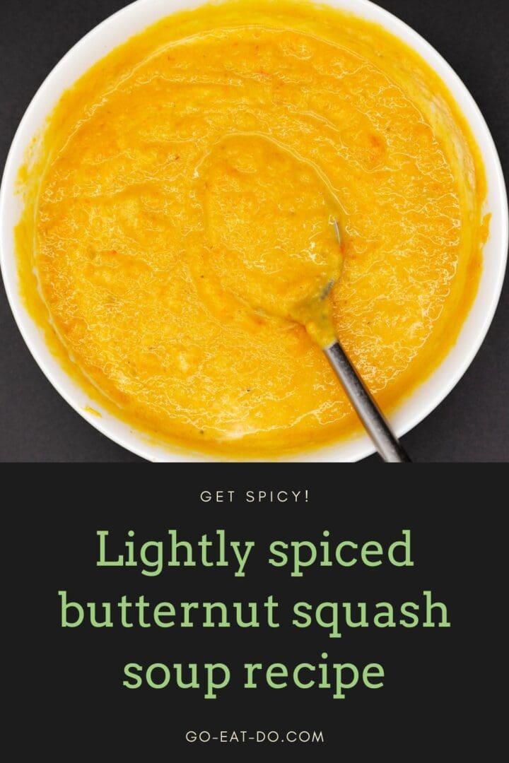 Pinterest pin to Go Eat Do's blog post with an easy-to-make lightly spiced butternut squash soup recipe showing the soup in a bowl with a spoon