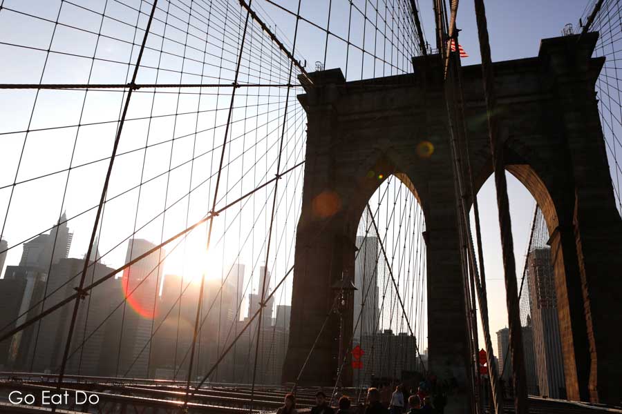 The semi-silhouetted Brooklyn Bridge on a sunny evening in New York City
