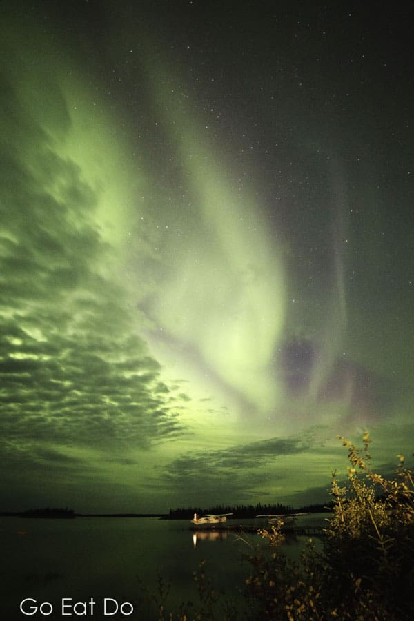 Northern lights glowing in night sky above Lake Egenolf in northern Manitoba, Canada