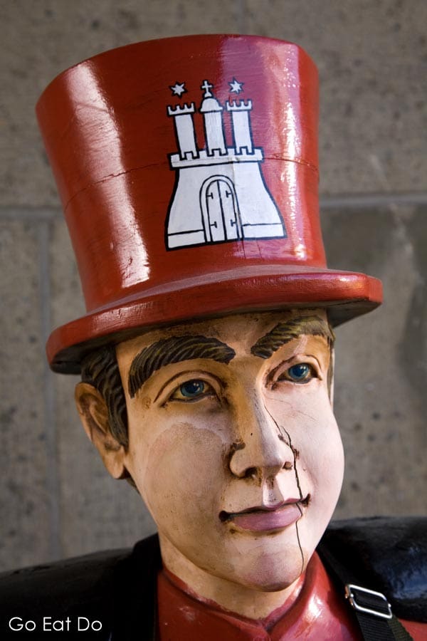 The wooden figure of Herr Hummel, the legendary water carrier, wearing a hat displaying the city crest of Hamburg, Germany