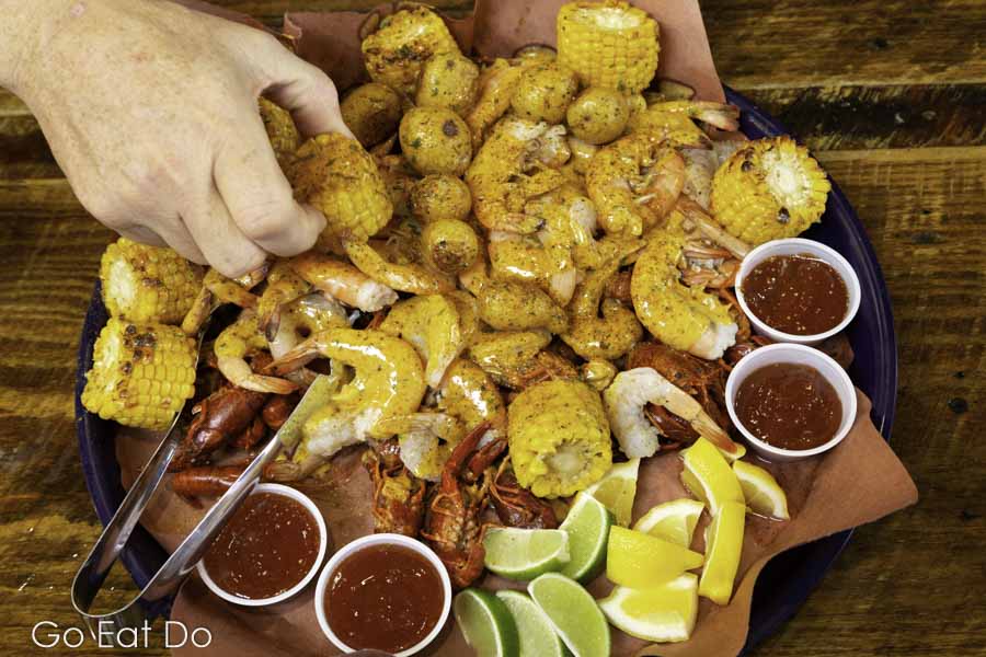 Grilled shrimp, sweetcorn and dipping sauces on a seafood platter served at Piggyback's Barbeque and Catfish restaurant at Lake City in South Carolina