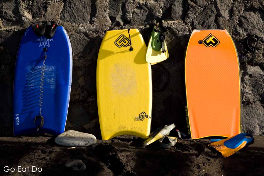 Colourful bodyboards and flippers by a beach wall at Taganana on Tenerife