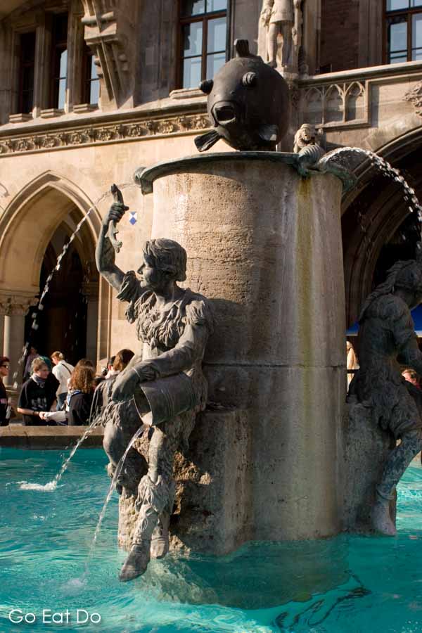 Water pours from statues on the Fish Fountain (Fischbrunnen) on Marienplatz, in Munich, Germany