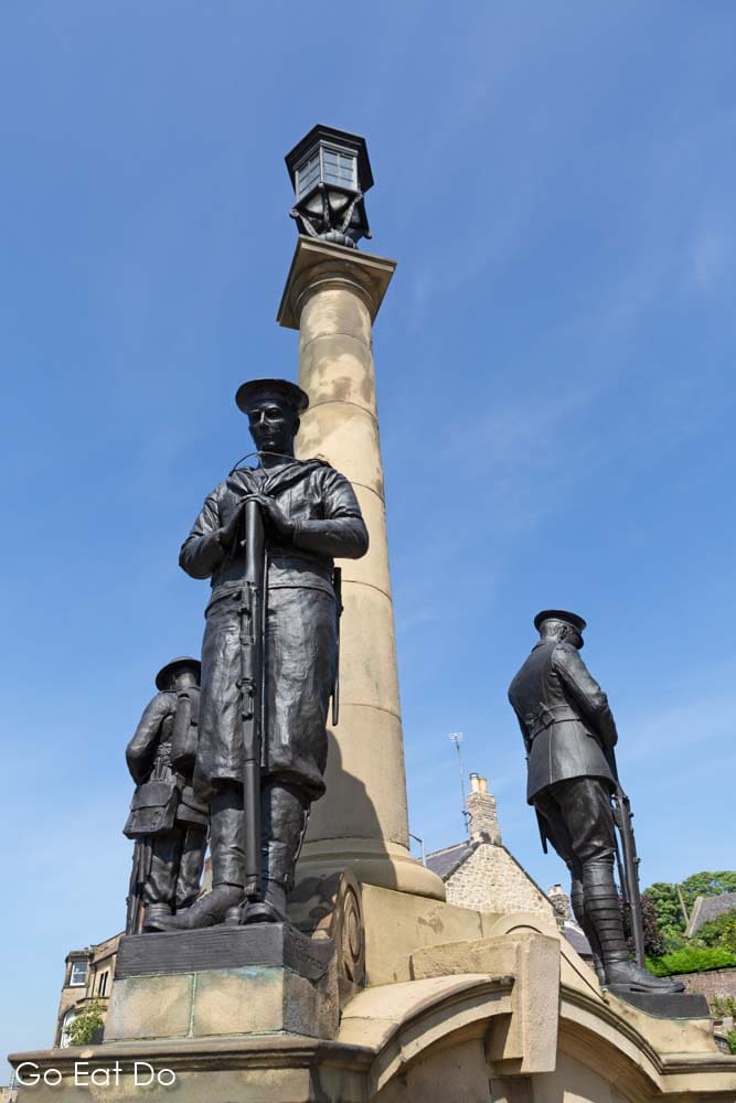 Statues of sailors and soldiers with bowed heads at the War Memorial in Alnwick, Northumberland