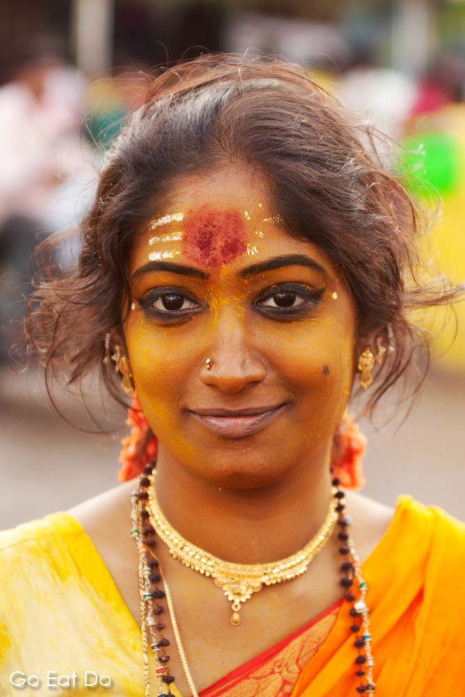 Face of a smiling woman wearing a yellow sari on the way to the firewalking festival in Bengaluru (Bangalore), India