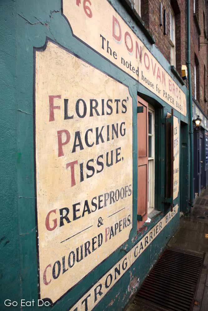 Advert for packing tissue on the painted facade of the Donovan Bros store in London, England.