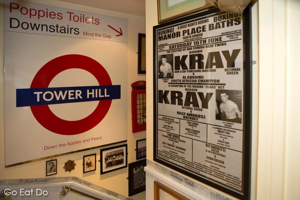 A poster for a boxing programme featuring Ronnie and Reggie Kray at Poppie's fish and chip shop in east London, England