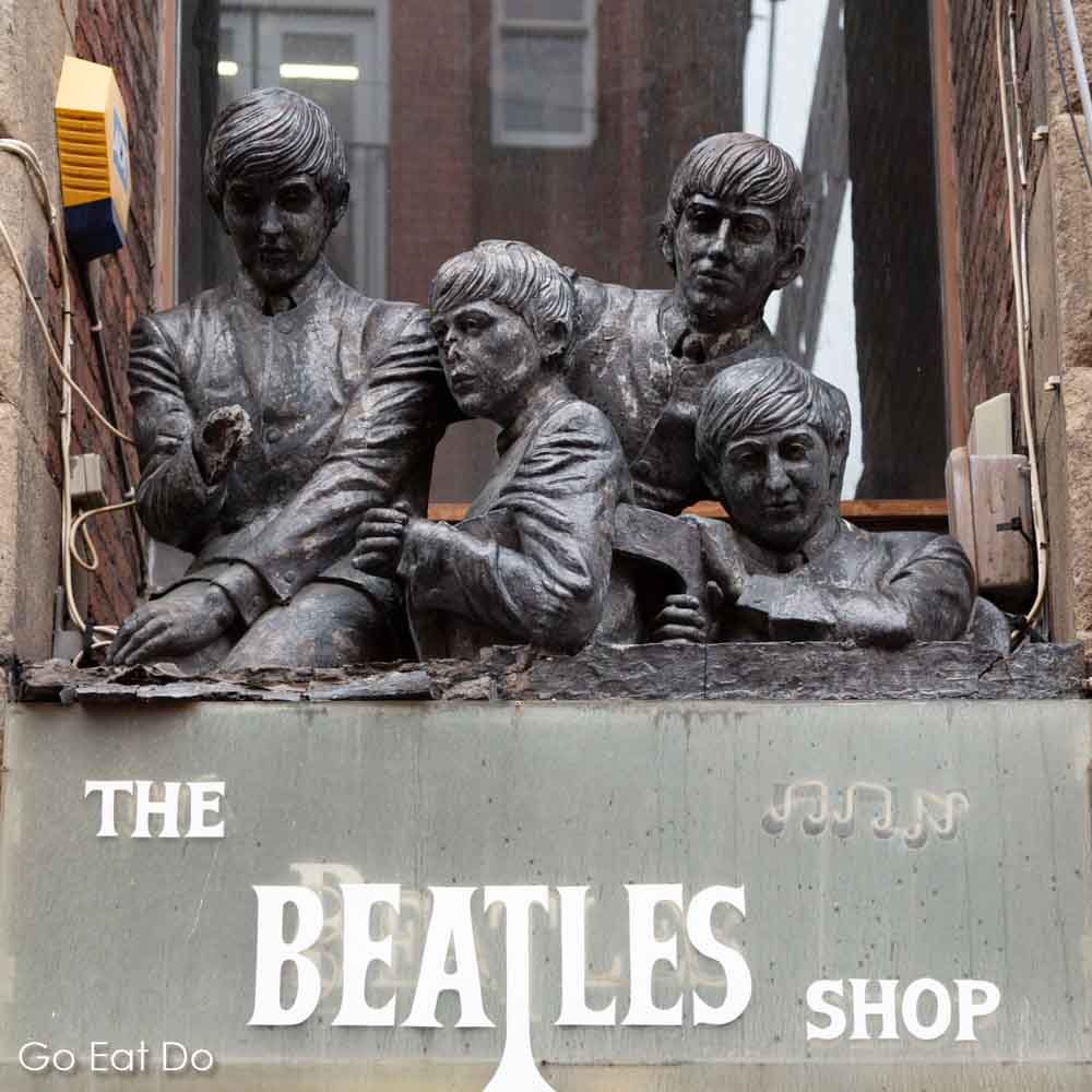 Statue depicting Paul McCartney, George Harrison, Ringo Starr and John Lennon above The Beatles Shop on Matthew Street in Liverpool, England