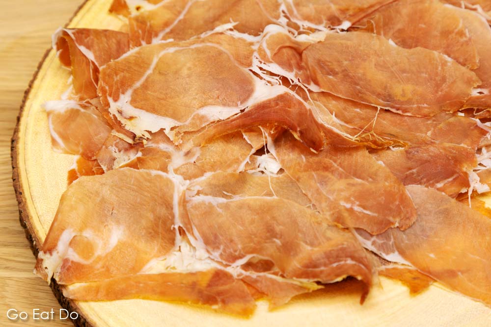 Slices of Parma ham (Prosciutto di Parma) presented on a wooden board