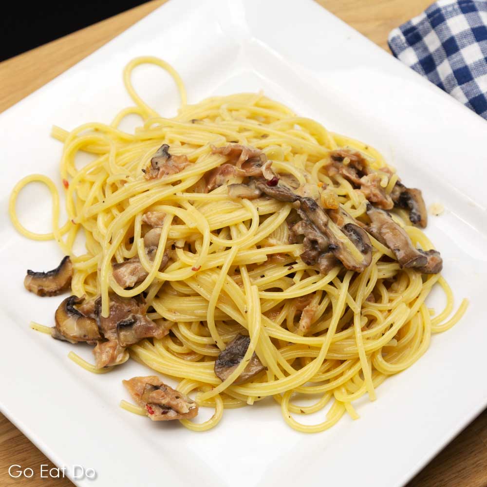 A plate of spaghetti carbonara made with Parma Ham and mushrooms