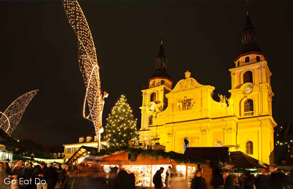 Christmas market stalls and the illuminated facade of the Baroque church in Ludwigsburg, near Stuttgart in south-west Germany
