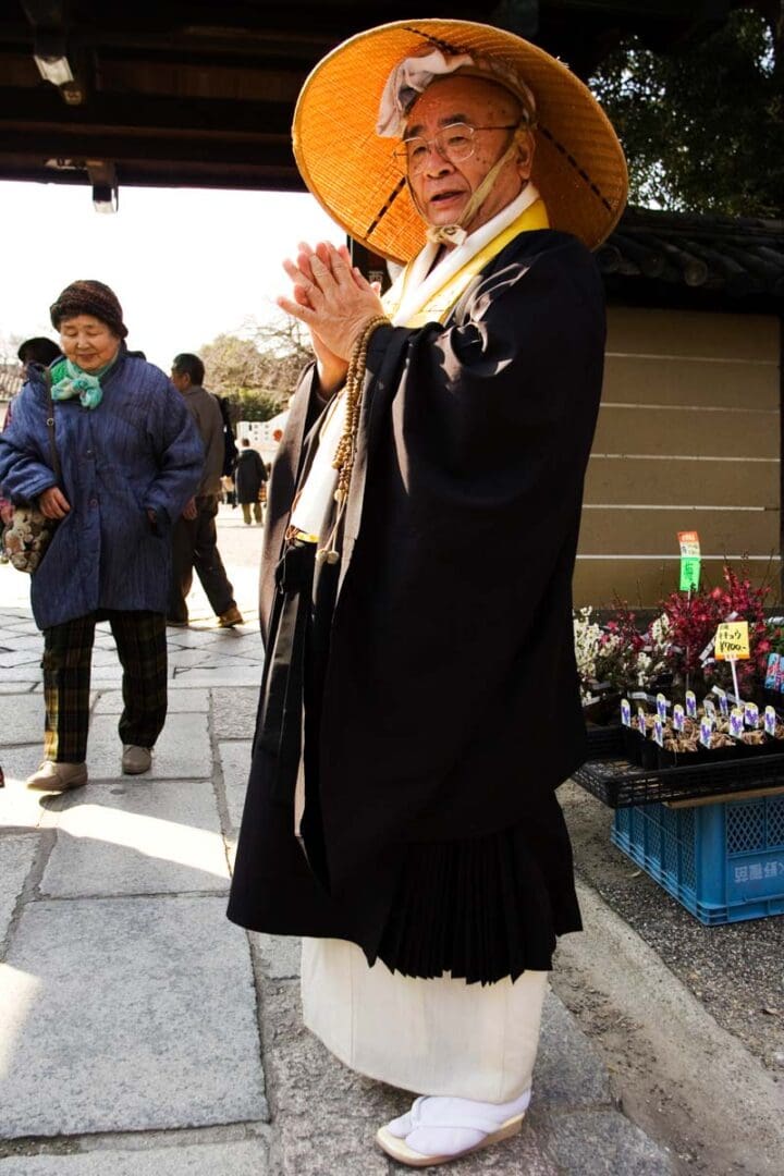 A priest wearing a kimono and straw hat on the day of the Kobo-san monthly market at the Toji Temple in Kyoto, Japan