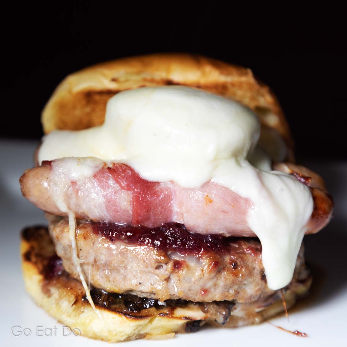 Christmas burger made with a turkey burger, cranberry sauce and pigs in blankets in a toasted brioche bun.