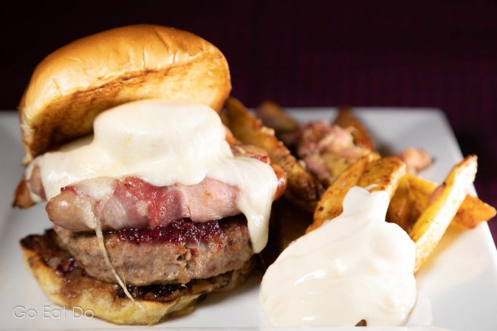 Christmas burger served in a brioche bun with a side of dirty fries and a garlic mayo dip.