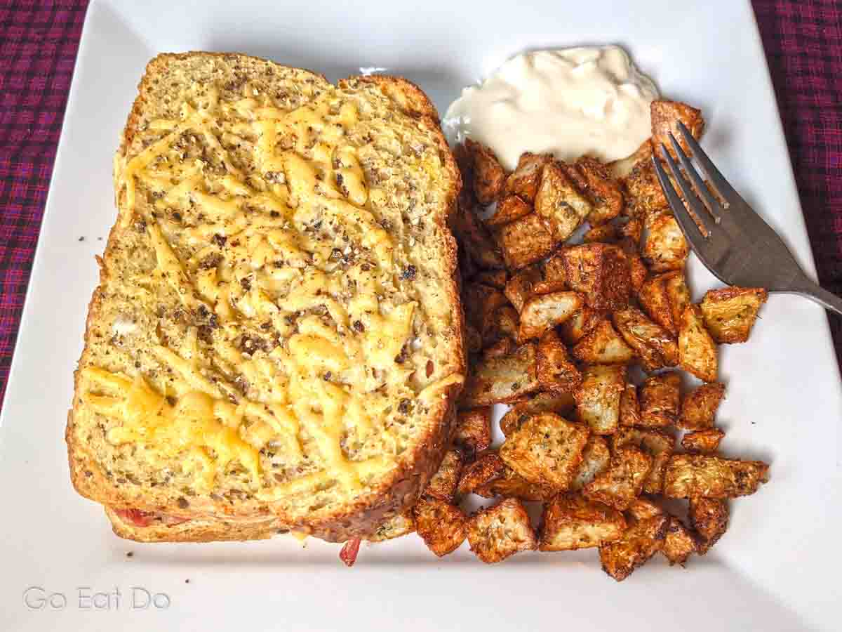 Tater tots crusted with herbs are ideal as a side to accompany this oven-baked sandwich.