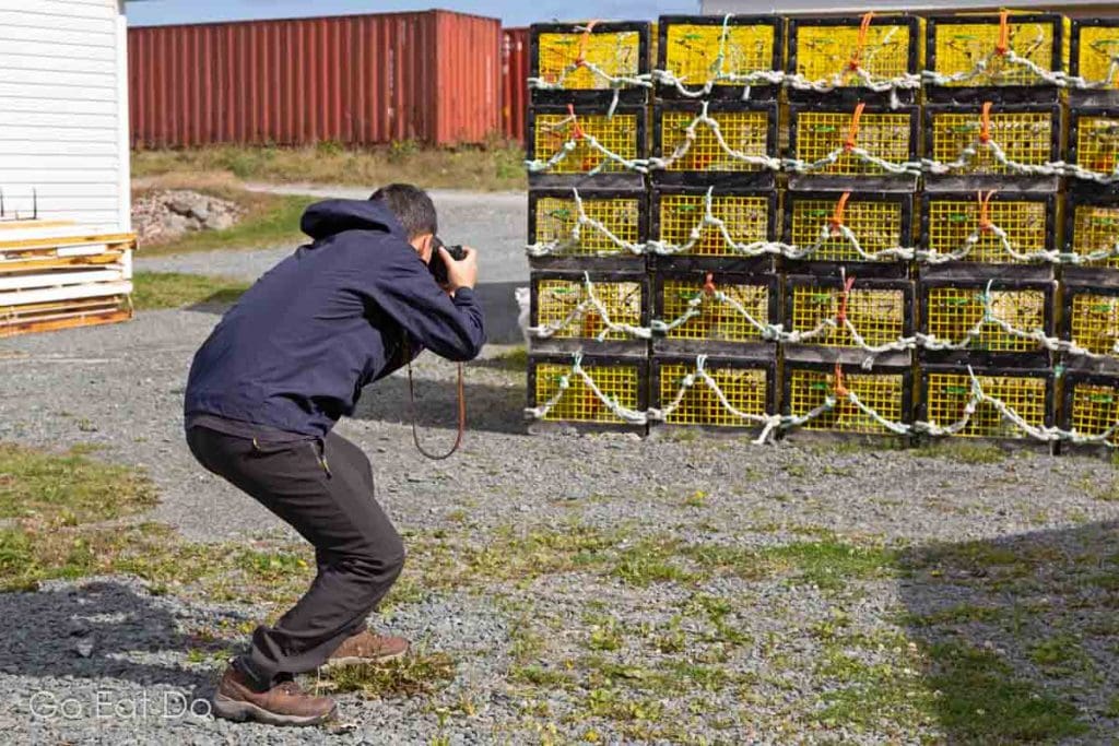 A man photographs lobster traps at Fisherman’s Reserve, a working fishing village on Nova Scotia's East Shore.