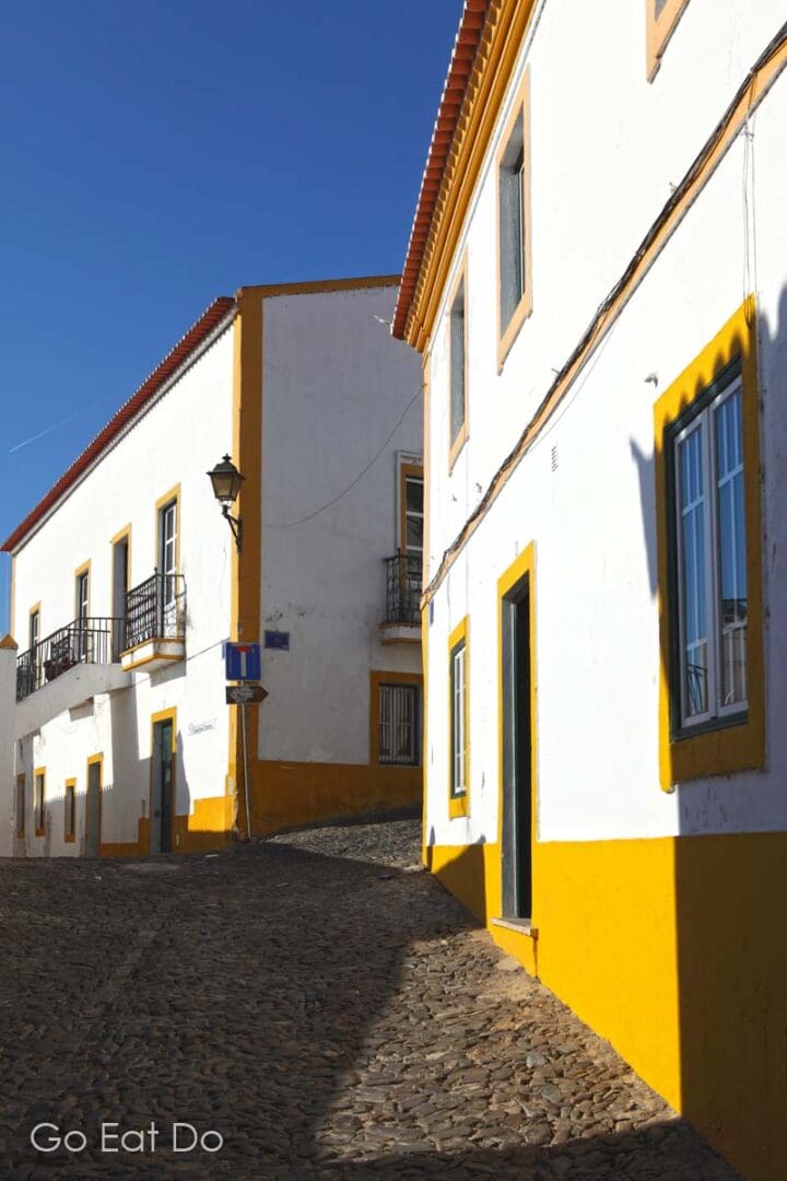 White houses in Mertola with colourful painted borders, typical of regional architecture and decoration in the Alentejo, Portugal.