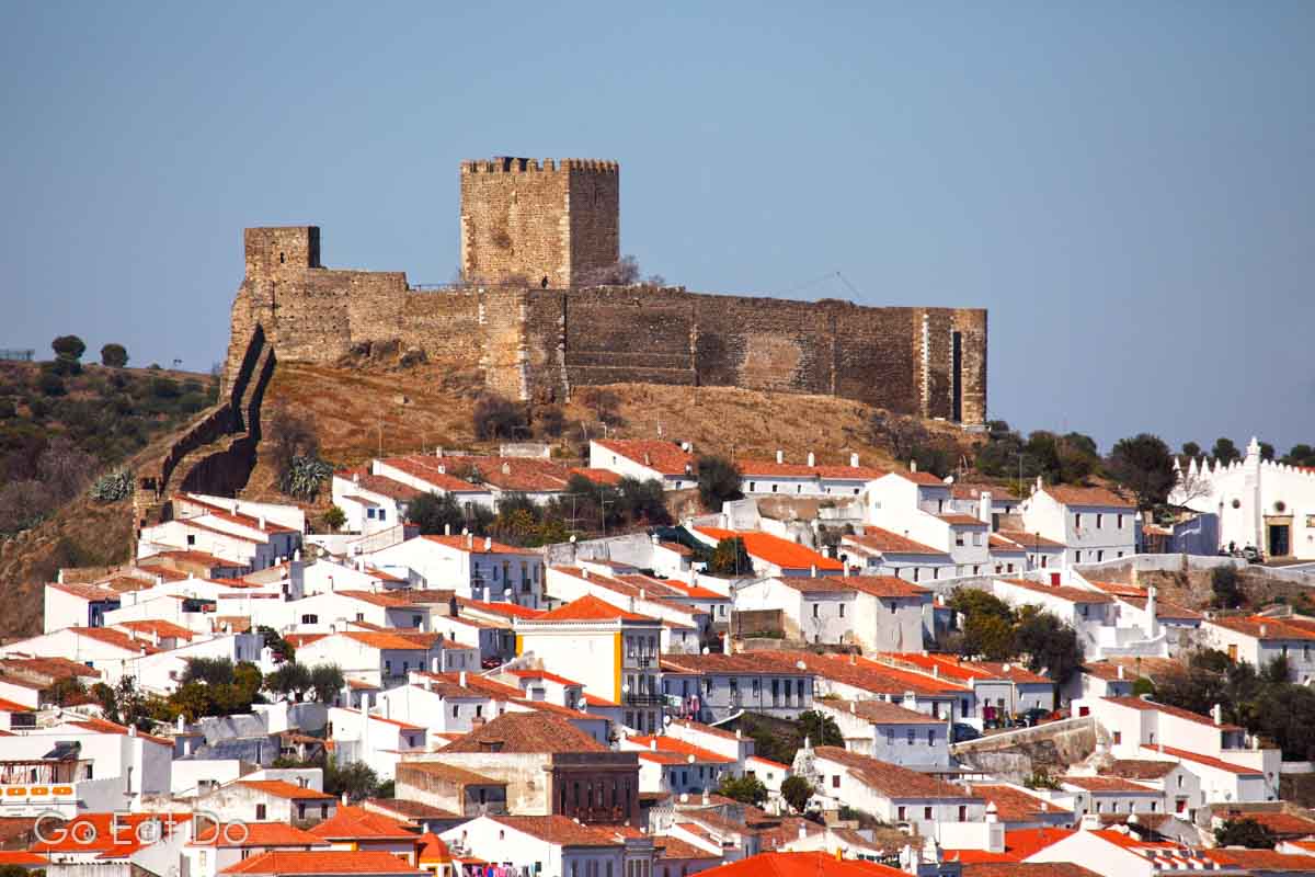 Mertola's medieval castle, one of the top places to visit in Mertola.,overlooks white houses in the walled city.