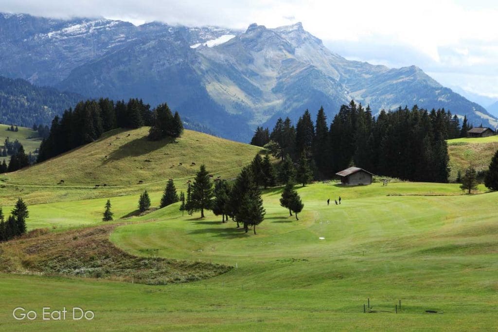 Golfers on the fairway of the 18-hole golf course at Villars, Switzerland. The undulating course is built on the side of the valley.