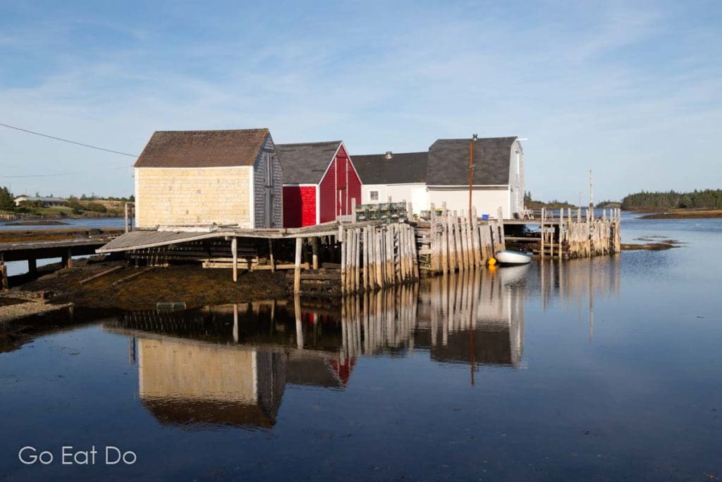 Rustic fishing shacks reflecting in the water at Blue Rocks near Lunenburg in Nova Scotia.