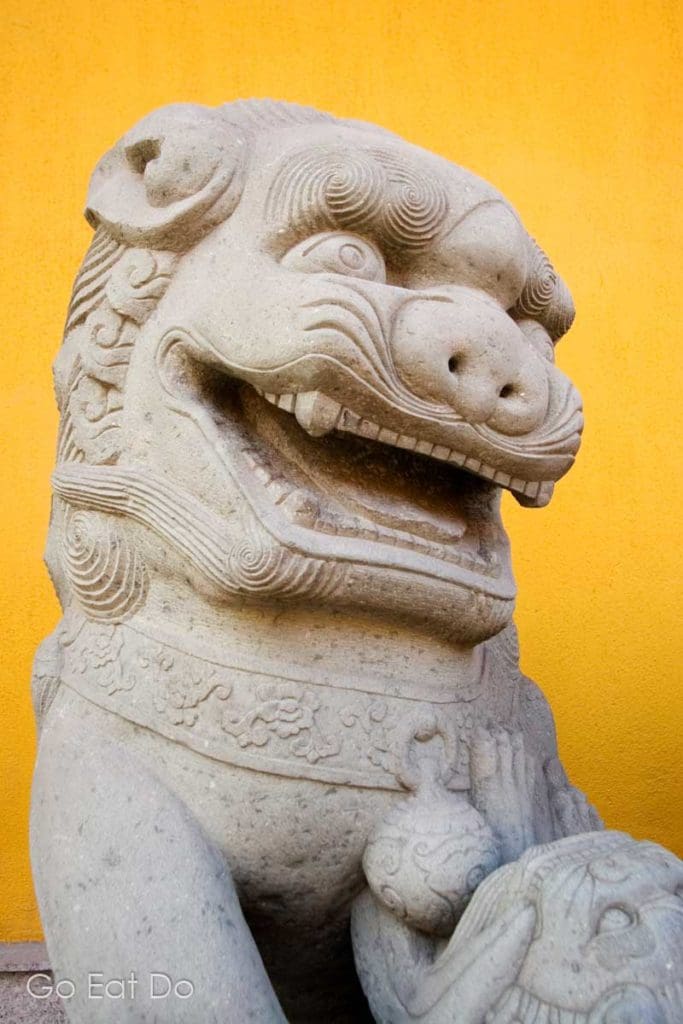 A stylised statue of a lion guarding the Jade Buddha Temple in Shanghai, China