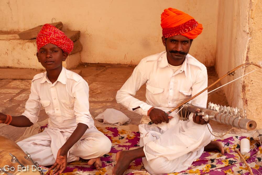 Rajasthani musicians in boldly coloured turbans playing near the entrance to Mehrangarh Fort in northern India.